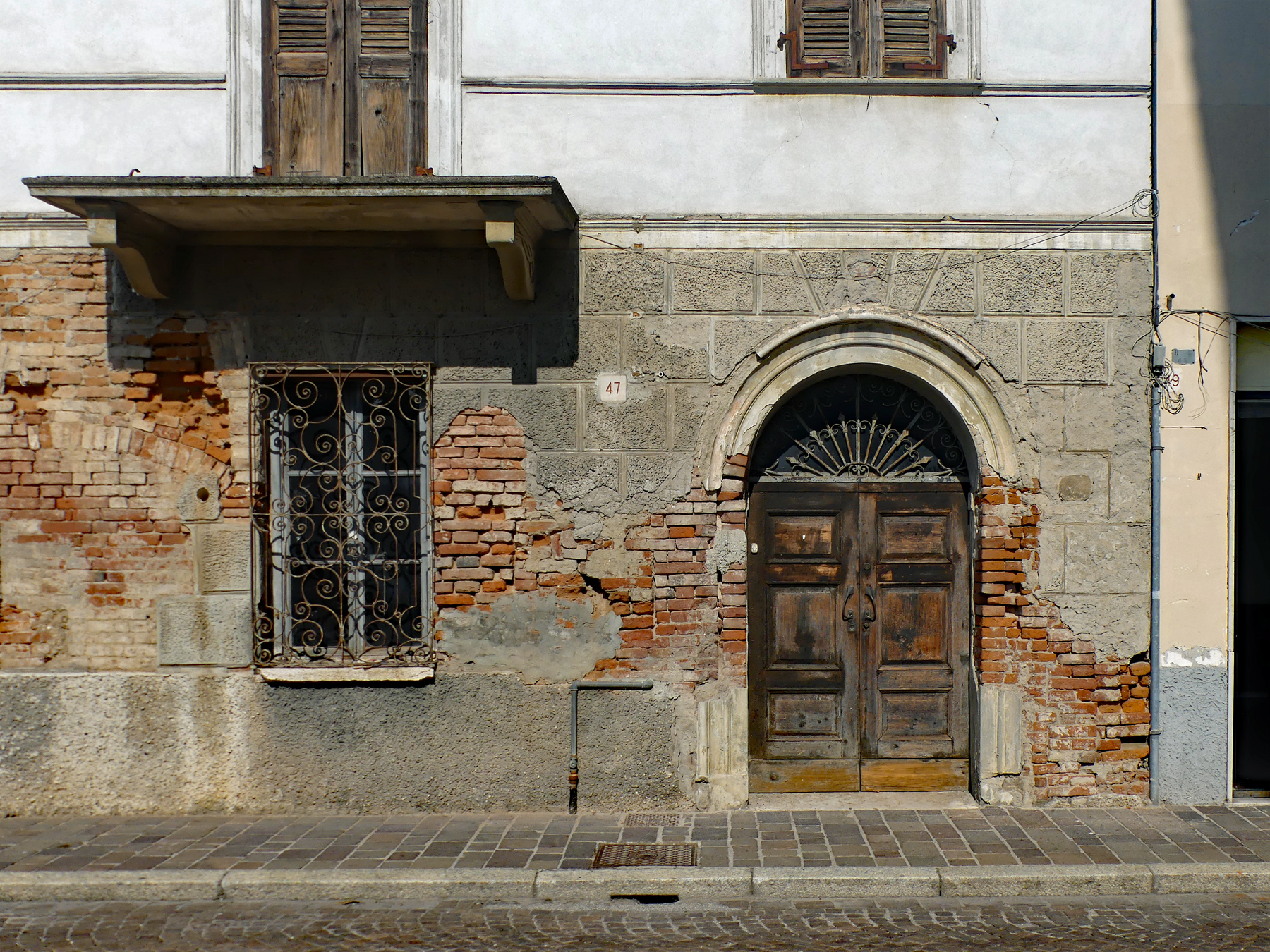 Alte Hausfront mit schmiedeeisernem Fenstergitter